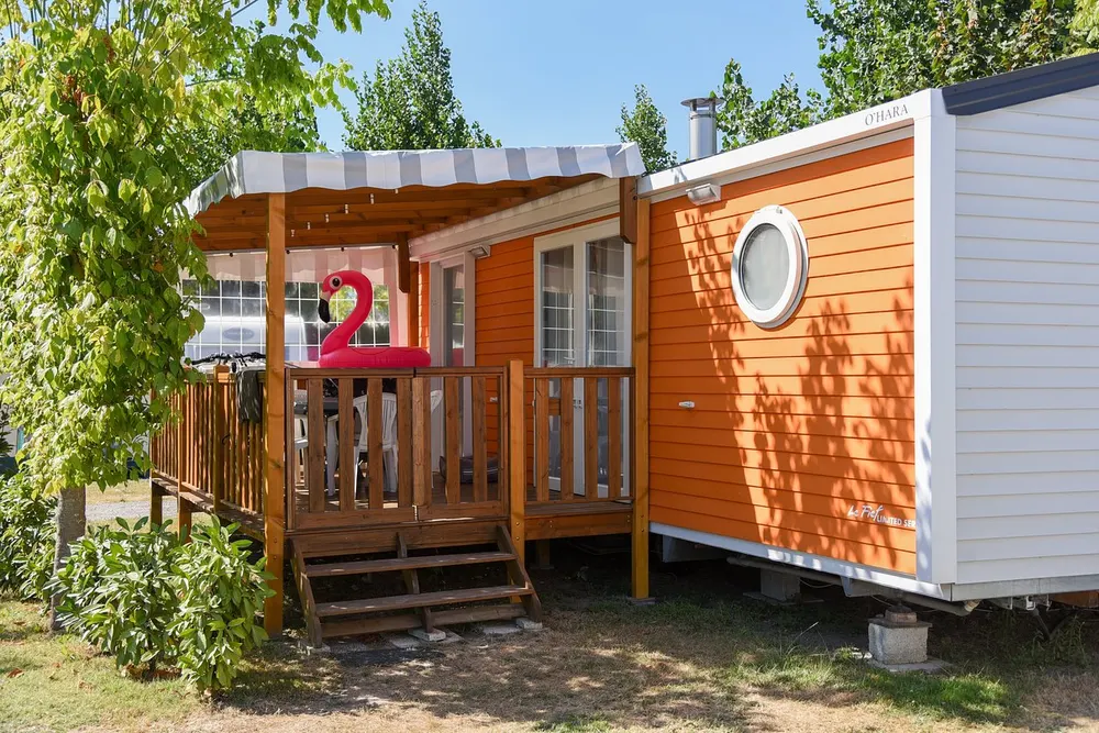 Mobil-home orange avec terrasse couverte