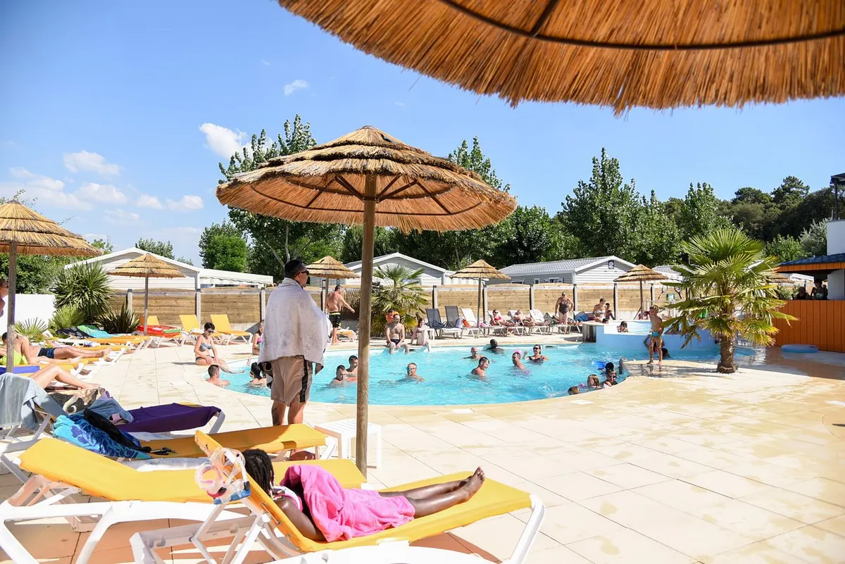 La piscine du camping, ses parasols et son solarium