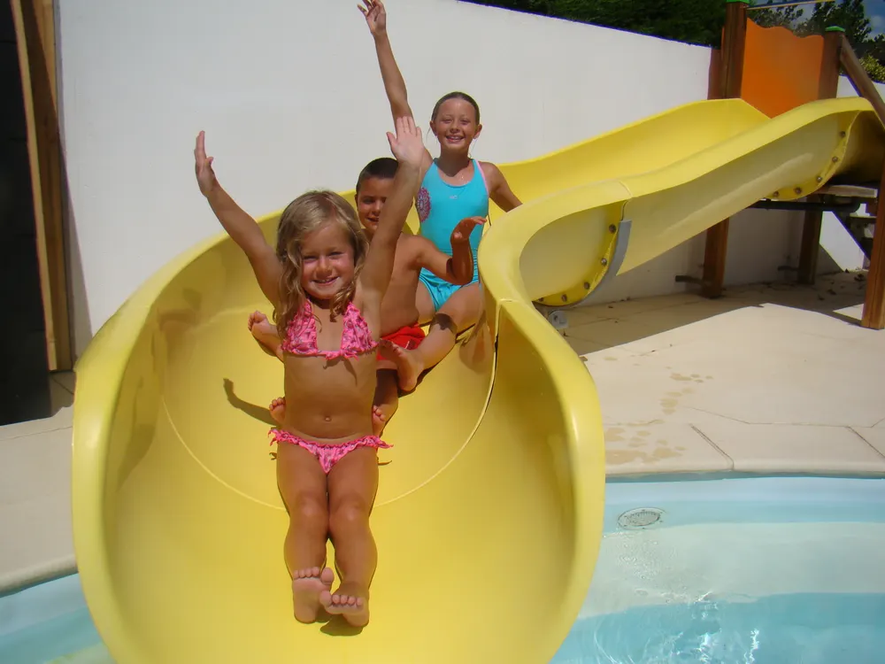 Enfants sur le toboggan jaune de la pataugeoire