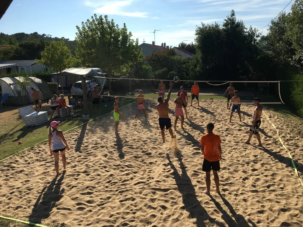 Partie de beach volley sur le terrain du camping